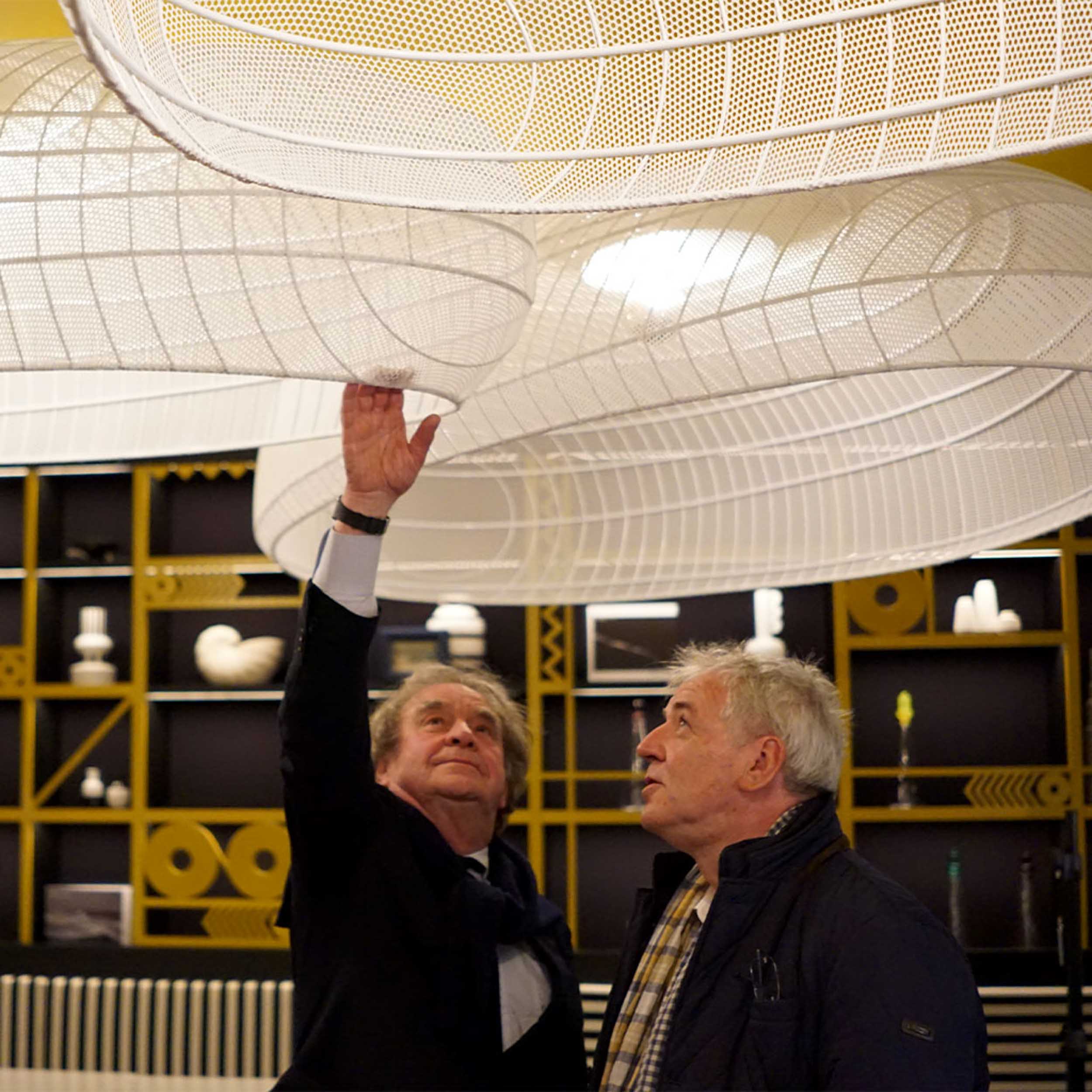 Deux hommes observant un luminaire design