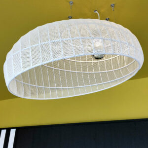 Gros plan sur un luminaire suspendu en métal blanc avec structure grillagée