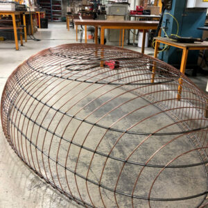 Grande structure métallique en cours de fabrication pour un luminaire suspendu