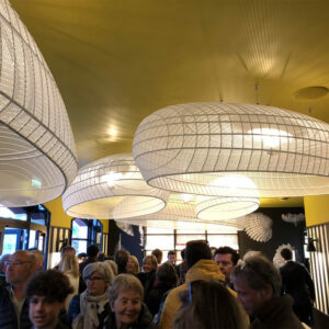 Soirée d’inauguration d’un restaurant avec de nombreux convives sous des luminaires design