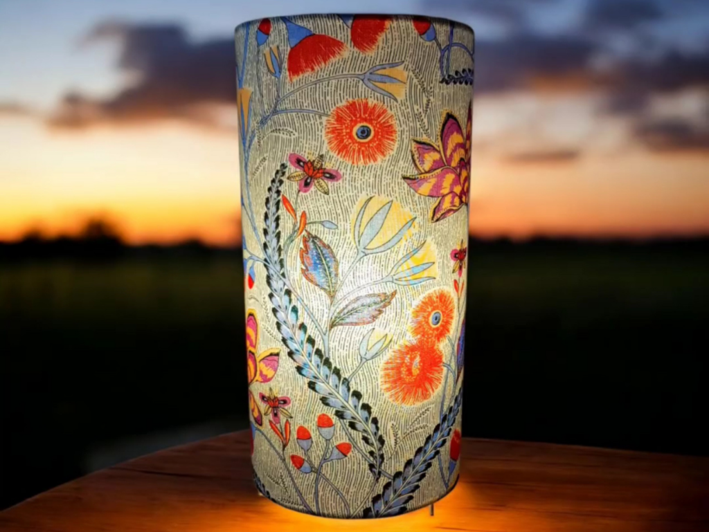 Lampe cylindrique en tissu floral illuminée au crépuscule, ambiance poétique